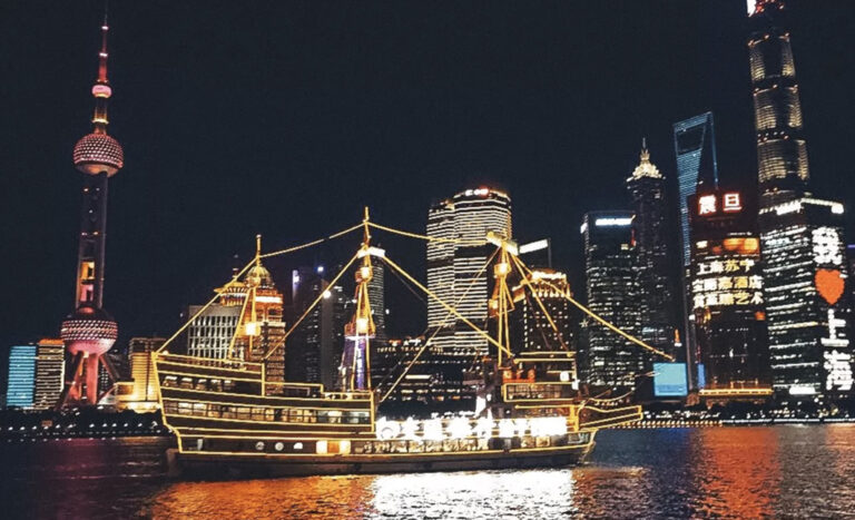 Die beleuchtete Skyline von Xi'an mit Schiff im Vordergrund