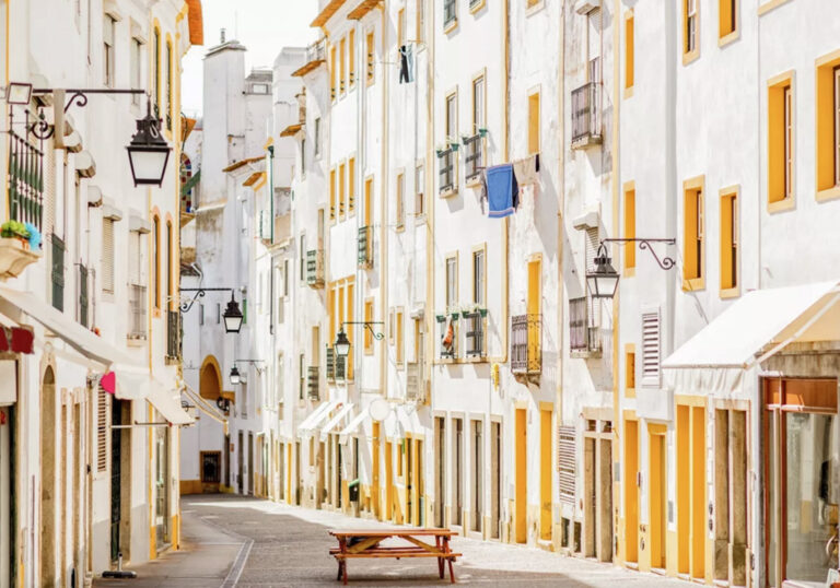 Bank vor bunten Fassaden in Evora