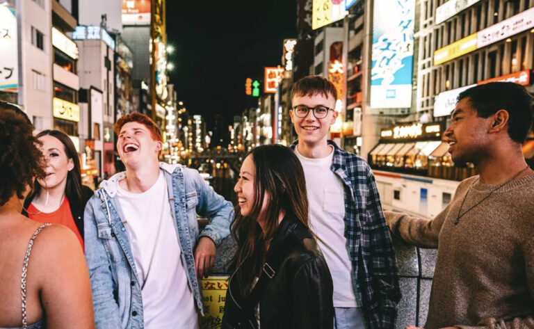 Gruppe vor Dotonbori Kanal und Neonlichtern