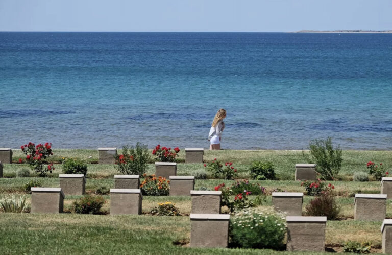 Reisende am Strand vor Friedhof