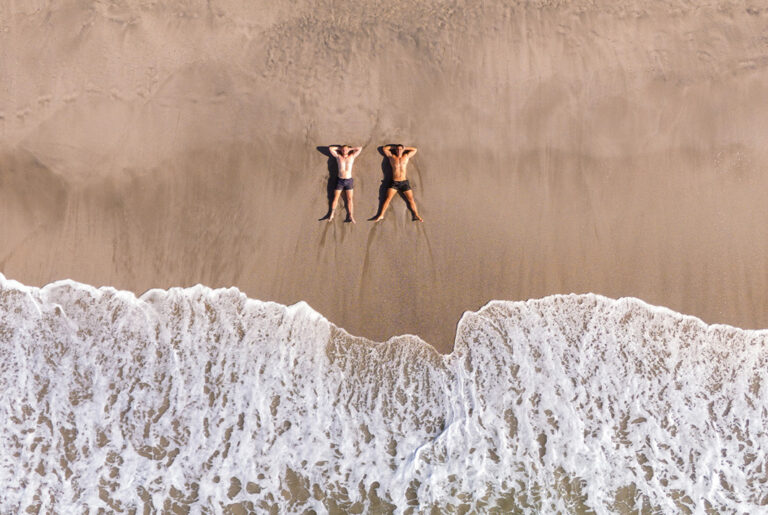 Zwei Reisende liegen am Strand