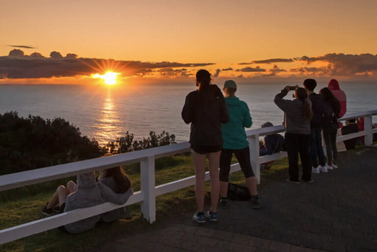 Gruppe bei Sonnenaufgang am Aussichtspunkt in Byron Bay