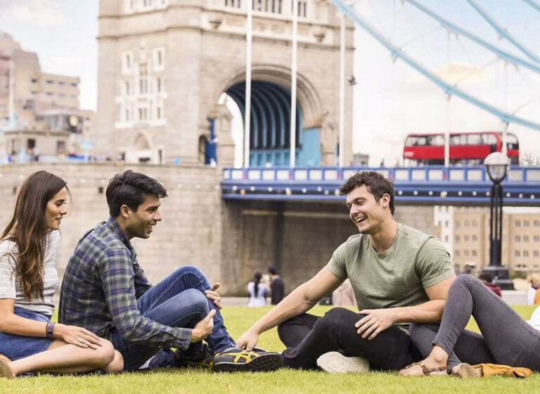 Junge Leute auf Wiese mit der Tower Bridge im Hintergrund