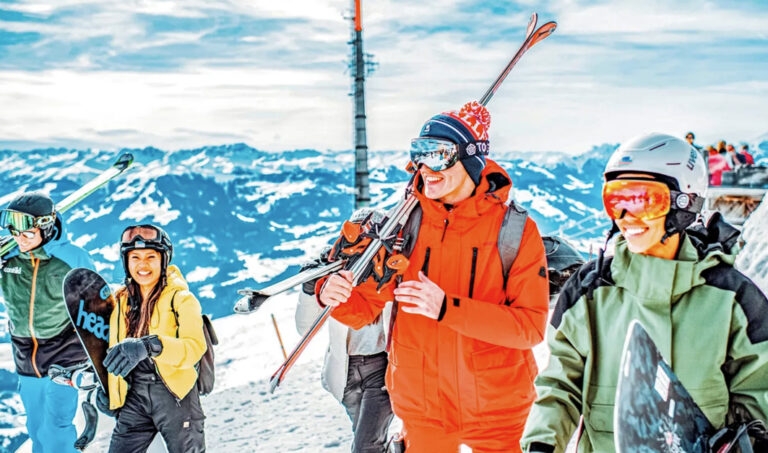 Gruppe geht mit abgeschnallten Skiern und Snowboards