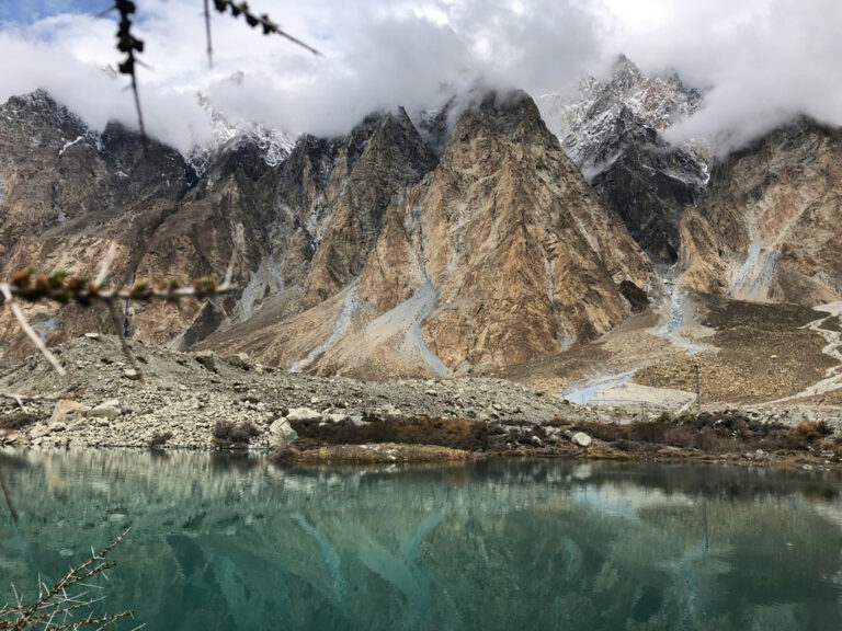 Wolkenverhangene Berge spiegeln sich auf der Wasseroberfläche