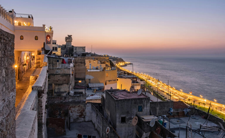 Blick auf Häuserdächer und das Meer bei Sonnenuntergang