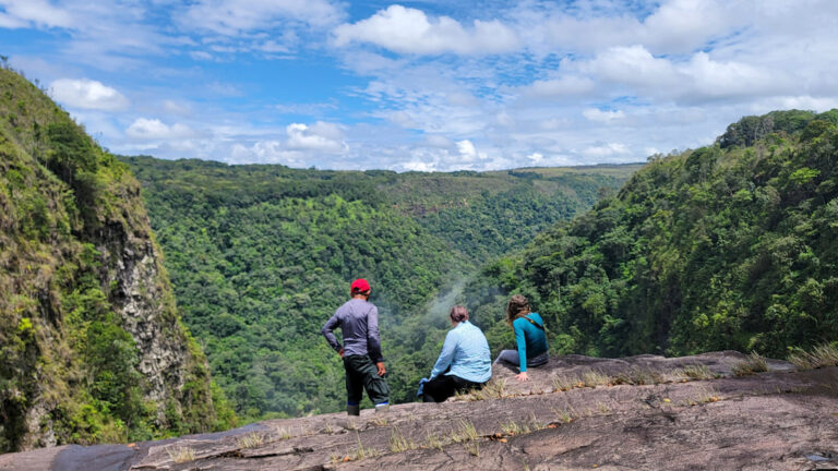 3 Wanderer genießen den Ausblick auf den Dschungel unter ihnen