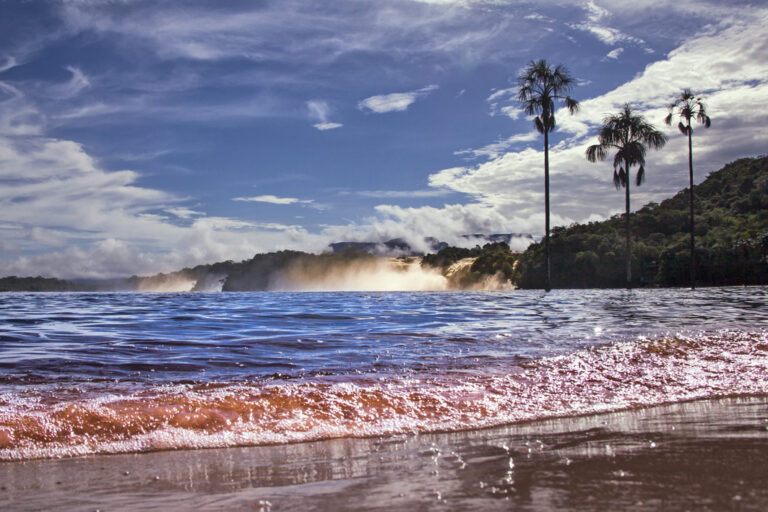 Strand und Palmen mit dem Sapo Wasserfall im Hintergrund
