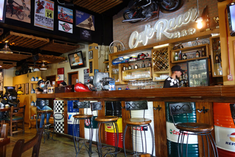 Bar mit Rennfahrereinrichtung und Ölfässern als Tresen