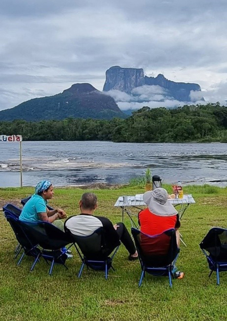 Camper in Campingstühlen mit Blick auf den Tepui Autana Berg