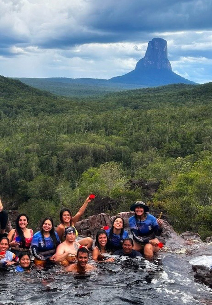 Gruppenbild im Naturpool mit Tepui Autana Berg im Hintergrund