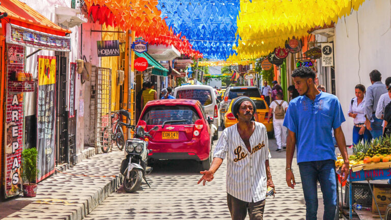 Zwei Männer laufen durch eine geschmückte Straße in Cartagena