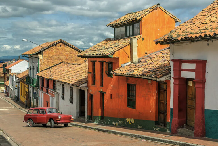 Altes Auto vor bunten Häusern am Hang