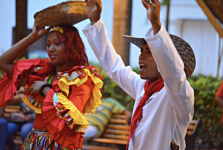 Traditionell gekleidete Kolumbianer feiern mit erhobenen Armen
