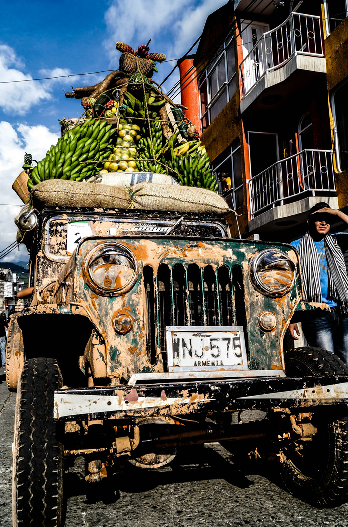 Dreckiger Jeep mit riesigem Obstberg auf dem Dach