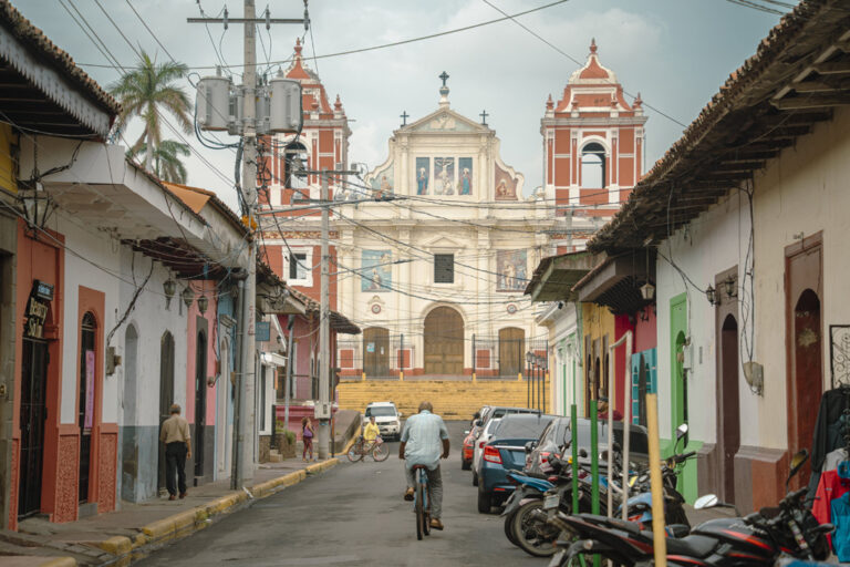 Mann auf Fahrrad fährt auf Kirche in Leon zu