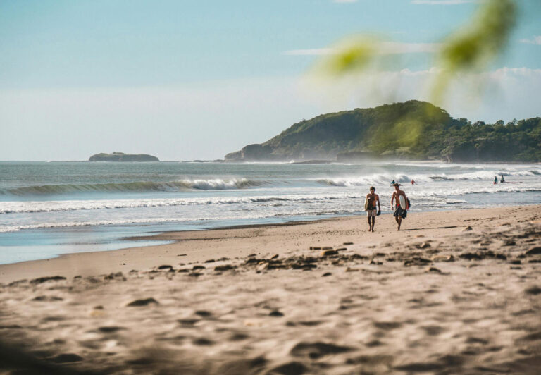 Zwei Leute spazieren am Strand entlang