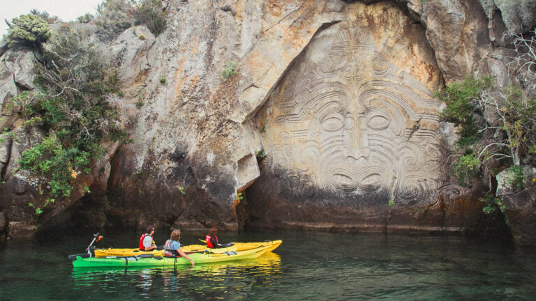 Kajak vor Maori Zeichnung im Felsen