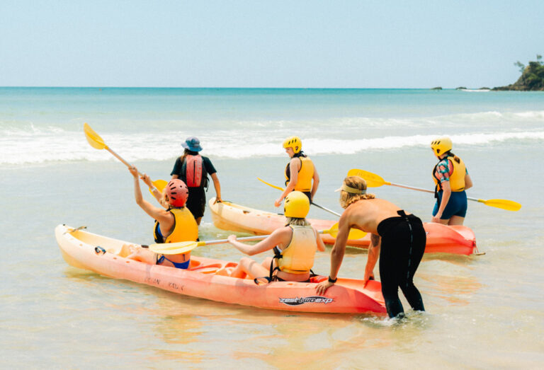 Kajak werden am Strand ins Wasser gelassen