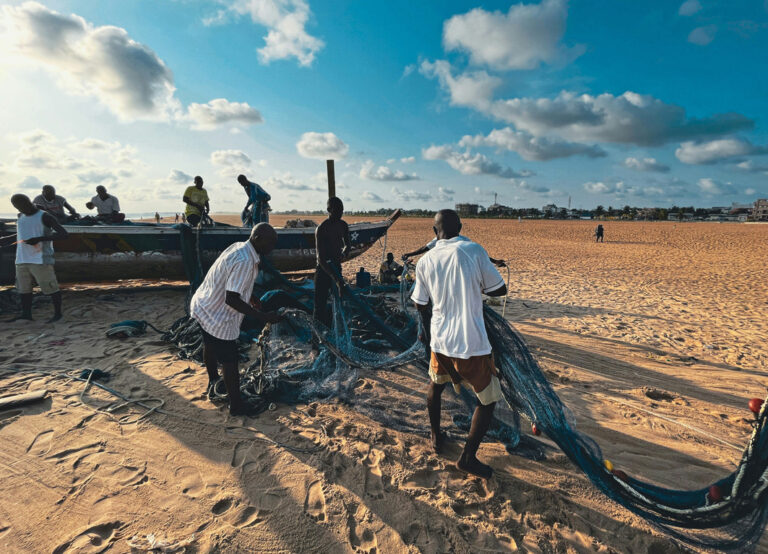 Fischer mit Netzen am Strand