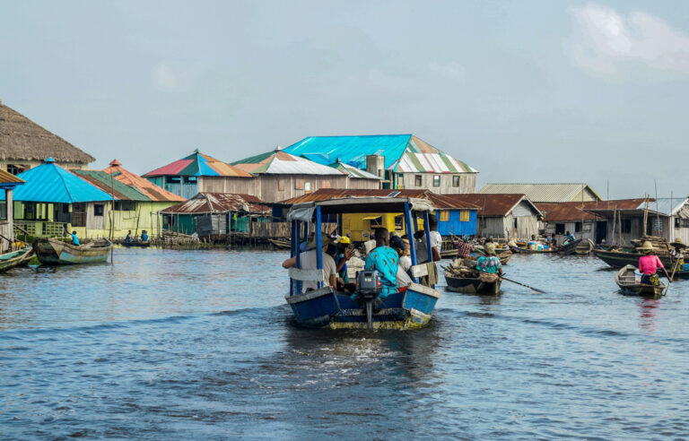 Boote fahren auf die Häuser auf dem Waser zu