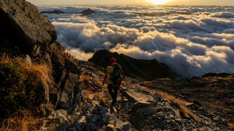 Mann mit Backpack über den Wolken in den Rocky Mountains
